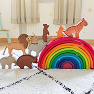 Holzspielzeug, Tierfiguren und bunter Regenbogen im Kinderzimmer