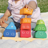 Grimms Holzspielzeug, bunte Bauklötze mit spielendem Kind