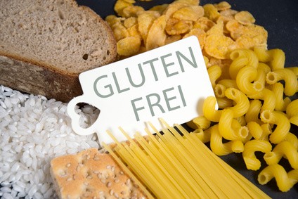 In der Mitte ist ein Schild mit der Aufschrift "Glutenfrei", durmherum liegen Brot, Kornflakes, Nudeln und Reis.